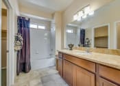 Thumbnail 18 of 25 - a bathroom with a shower and a sink and a mirror