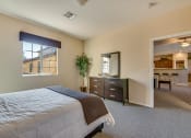 Thumbnail 7 of 25 - a bedroom with a bed and a dresser and a window