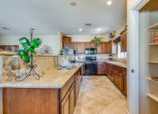Thumbnail 11 of 25 - a kitchen with wooden cabinets and granite counter tops