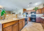 Thumbnail 10 of 25 - a large kitchen with wooden cabinets and a sink