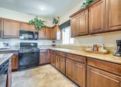 Thumbnail 19 of 25 - a kitchen with wooden cabinets and a counter top