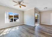 Thumbnail 9 of 23 - an empty living room with a ceiling fan and a window