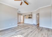 Thumbnail 6 of 23 - an empty living room with wood floors and a ceiling fan