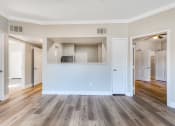 Thumbnail 8 of 23 - an open living room and kitchen with wood floors and white doors