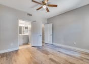 Thumbnail 12 of 23 - an empty living room with wood floors and a ceiling fan