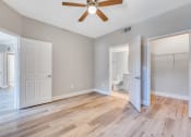 Thumbnail 13 of 23 - an empty room with a ceiling fan and a door to a bathroom