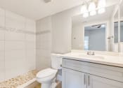 Thumbnail 15 of 23 - a bathroom with a toilet and a sink and a mirror
