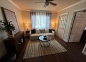 Thumbnail 8 of 14 - A living room with a white couch and a rug.