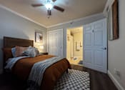 Thumbnail 1 of 14 - A bedroom with a bed, a ceiling fan, and a rug.