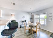 Thumbnail 8 of 25 - A dining room with a table and chairs.