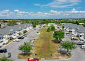Thumbnail 24 of 25 - A parking lot with cars and a grassy area in the middle.
