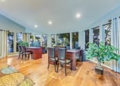 Thumbnail 19 of 25 - a dining room with a table and chairs and a living room with windows