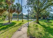 Thumbnail 6 of 25 - a path through a park with trees and benches