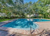 Thumbnail 13 of 25 - a swimming pool with trees in the background