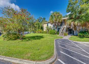 Thumbnail 16 of 25 - a house with a lawn and palm trees in front of it