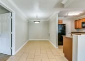 Thumbnail 17 of 25 - an empty kitchen and hallway with a door open to the living room