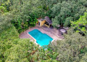 Thumbnail 3 of 25 - an aerial view of a pool in the middle of trees