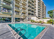 Thumbnail 4 of 32 - a swimming pool in front of an apartment building