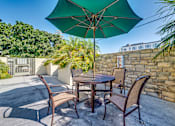 Thumbnail 3 of 32 - a patio with a table and chairs and an umbrella