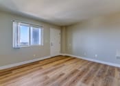Thumbnail 28 of 32 - an empty living room with wood flooring and a window