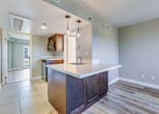 Thumbnail 16 of 32 - a kitchen with a white counter top and a wall with checkered wallpaper