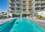 Thumbnail 11 of 32 - a large swimming pool in front of an apartment building