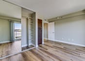 Thumbnail 27 of 32 - an empty living room with a mirrored wall and wood flooring