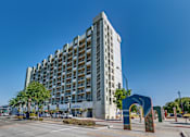 Thumbnail 19 of 32 - a tall building with a blue arch in front of it