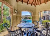 Thumbnail 3 of 25 - a patio with a table and chairs and a swimming pool