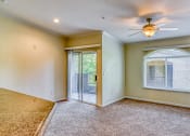 Thumbnail 25 of 25 - an empty living room with a ceiling fan and a door to a patio