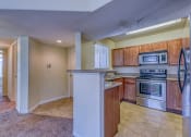 Thumbnail 23 of 25 - a kitchen with wooden cabinets and stainless steel appliances