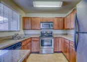 Thumbnail 10 of 25 - a kitchen with wooden cabinets and stainless steel appliances