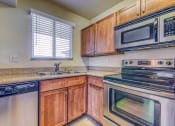 Thumbnail 11 of 25 - a kitchen with stainless steel appliances and wooden cabinets