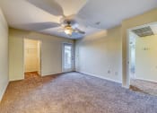 Thumbnail 16 of 25 - an empty living room with a ceiling fan and a door to a closet
