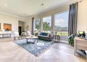 Thumbnail 29 of 32 - A spacious living room with a large window overlooking a green landscape.