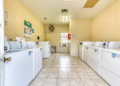 Thumbnail 30 of 32 - A laundromat with rows of washers and dryers.
