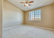 Thumbnail 10 of 30 - an empty living room with a ceiling fan and a window