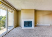 Thumbnail 14 of 17 - an empty living room with a fireplace and a sliding glass door