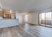 Thumbnail 4 of 32 - an open living room and kitchen with a sliding glass door to a balcony at Pacific Harbors Sunrise Apartments, Las Vegas, NV