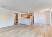 Thumbnail 22 of 32 - an empty living room with a kitchen in the background at Pacific Harbors Sunrise Apartments, Nevada