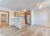 Thumbnail 19 of 32 - a kitchen and living room with hardwood floors and white walls at Pacific Harbors Sunrise Apartments, Las Vegas, NV, 89142