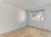 Thumbnail 29 of 32 - a bedroom with hardwood floors and a large window at Pacific Harbors Sunrise Apartments, Nevada, 89142