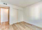 Thumbnail 28 of 32 - a bedroom with hardwood floors and white walls at Pacific Harbors Sunrise Apartments, Nevada