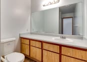 Thumbnail 32 of 32 - a bathroom with a toilet sink and mirror at Pacific Harbors Sunrise Apartments, Las Vegas, NV, 89142