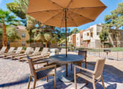 Thumbnail 11 of 32 - a patio with a table and chairs and an umbrella at Pacific Harbors Sunrise Apartments, Nevada, 89142