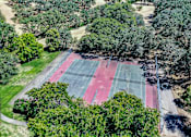 Thumbnail 35 of 43 - an aerial view of a tennis court surrounded by trees