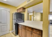 Thumbnail 16 of 39 - a kitchen with a refrigerator and wooden cabinets