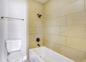 Thumbnail 26 of 39 - a bathroom with a toilet and a tub and a sink