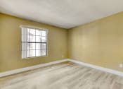 Thumbnail 24 of 39 - an empty living room with wood floors and a window