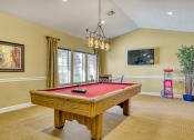 Thumbnail 37 of 39 - a game room with a red pool table and a chandelier